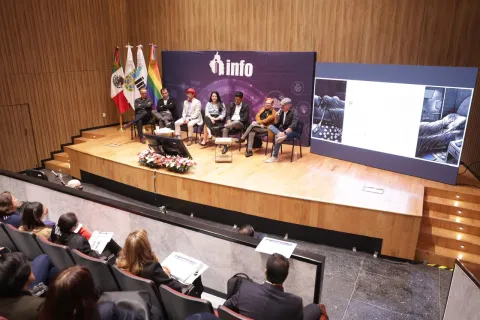 Personas ponentes del Foro Transparencia y Periodismo 2024 del INFO CDMX posan frente al fondo institucional.