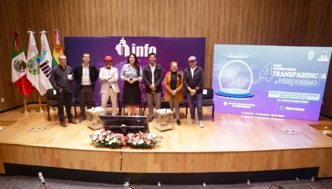 Personas ponentes del Foro Transparencia y Periodismo 2024 del INFO CDMX posan frente al fondo institucional.