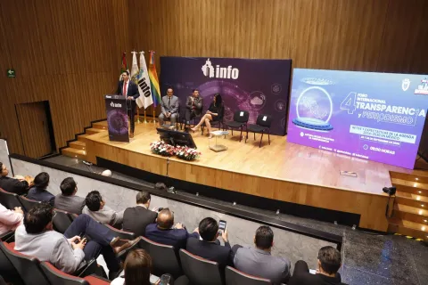 Personas ponentes del Foro Transparencia y Periodismo 2024 del INFO CDMX posan frente al fondo institucional.