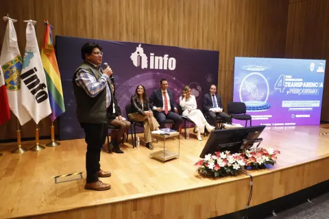Personas ponentes del Foro Transparencia y Periodismo 2024 del INFO CDMX posan frente al fondo institucional.